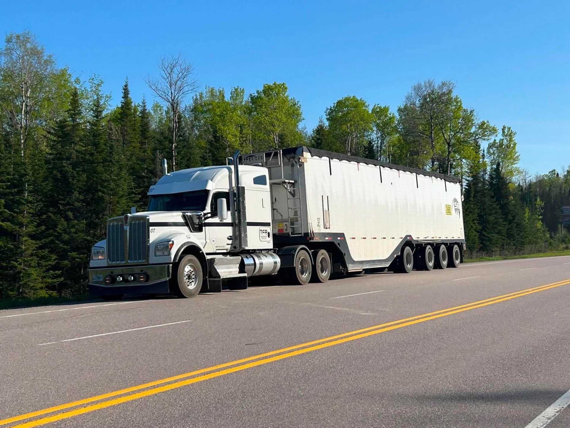 Western Star blanc TFB tirant une remorque à copeaux sur route forestière