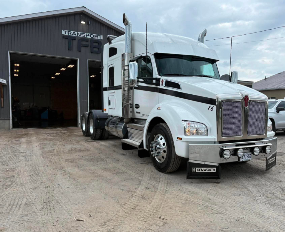 Camion Kenworth blanc TFB devant le garage à Saint-Honoré