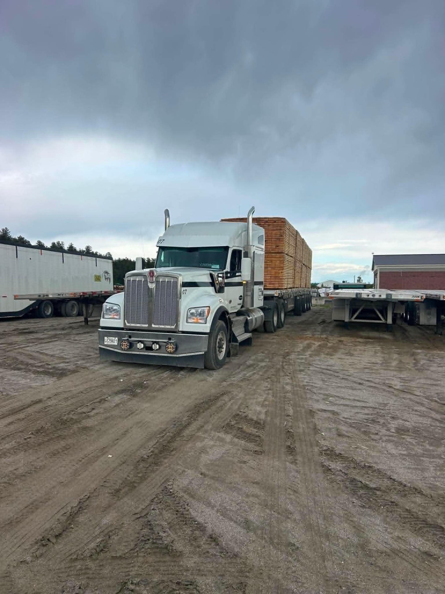 Kenworth blanc TFB avec flatbed chargé de bois de sciage à la scierie
