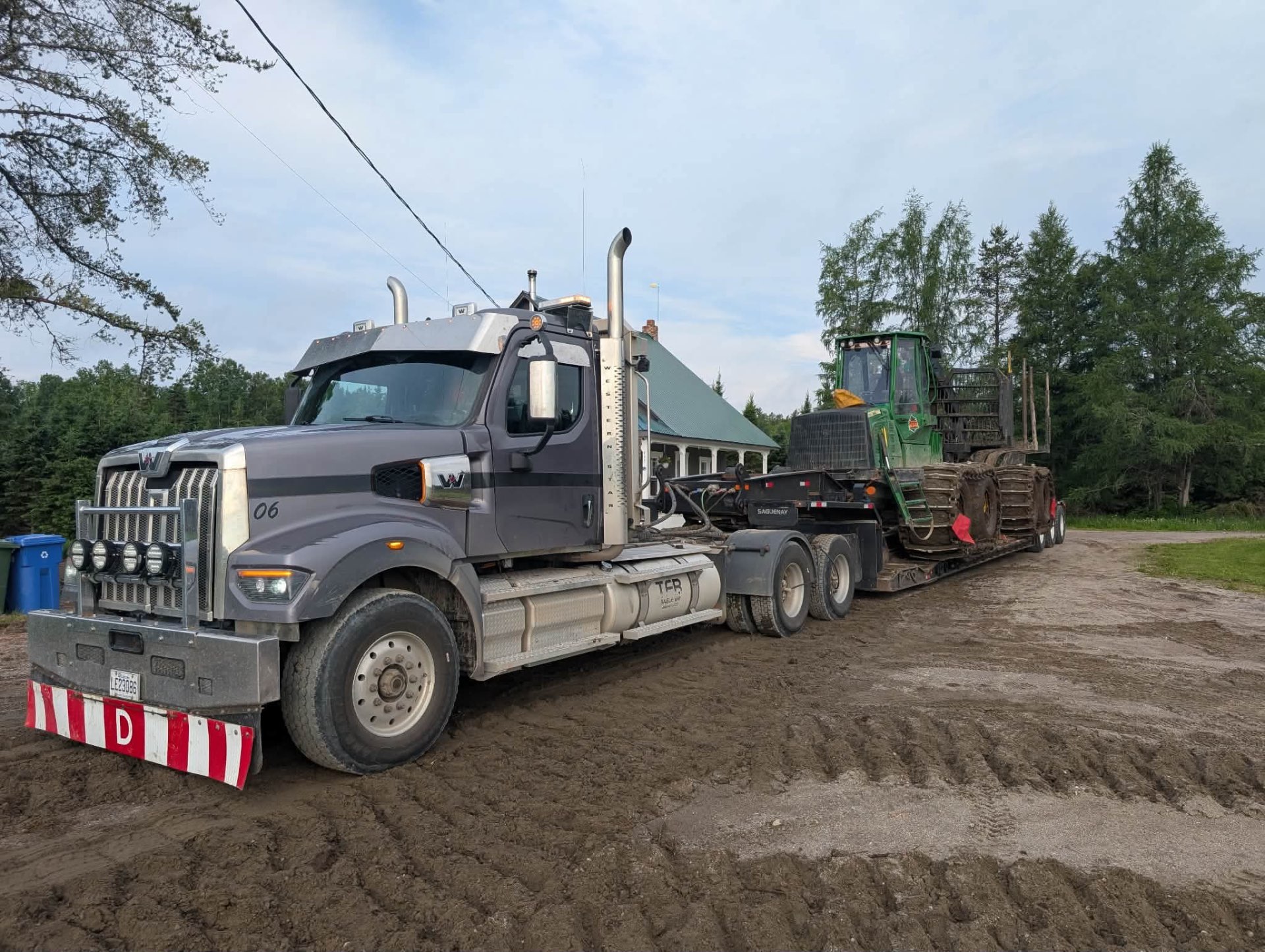 Western Star TFB avec fardier transportant une débusqueuse forestière John Deere